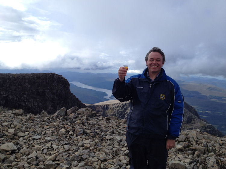 Neil at the Ben Nevis summit with Ben Nevis single malt whisky